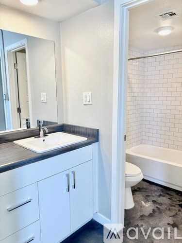 A bathroom with a white tub, sink, and toilet.