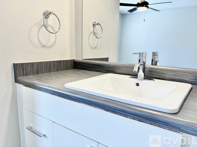 A white sink is on a countertop in a bathroom.