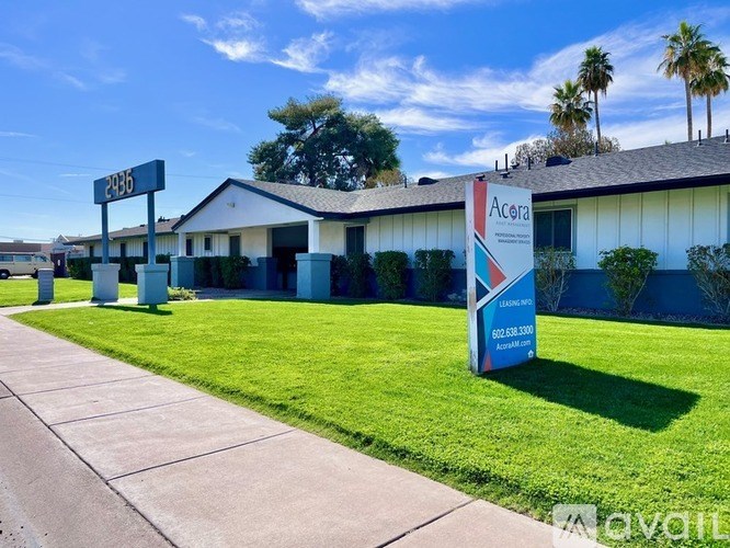 A sign for Acura is in front of a building.