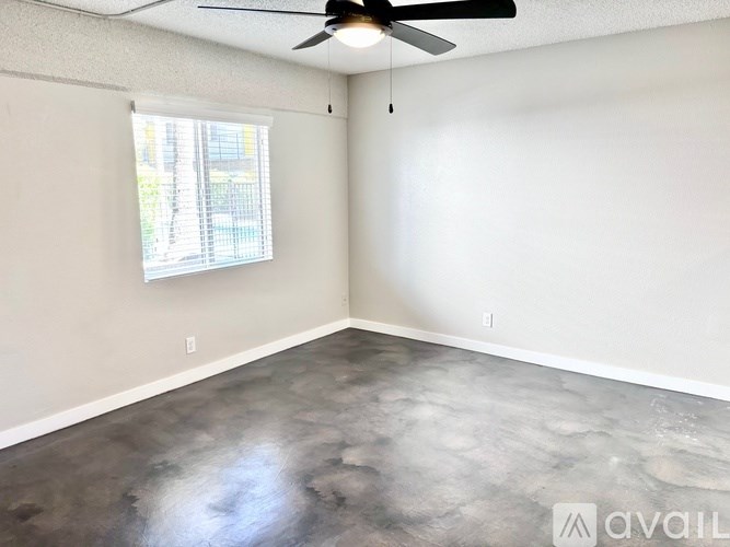 A room with a ceiling fan and a window.