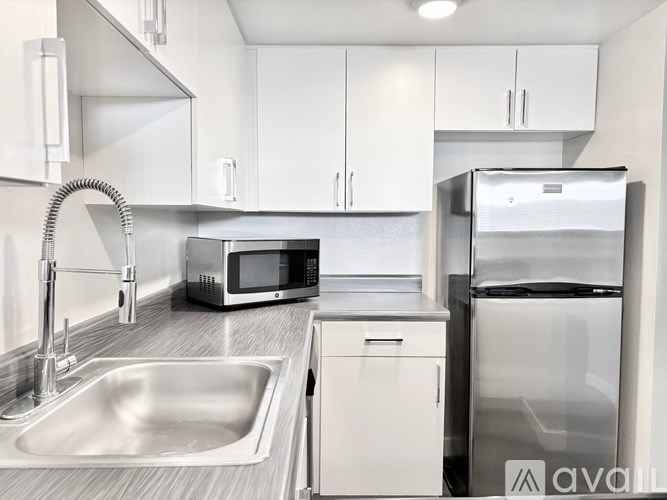 A kitchen with a sink, microwave, and refrigerator.