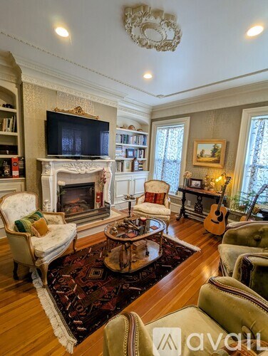 A living room with a fireplace and a television on the mantle.