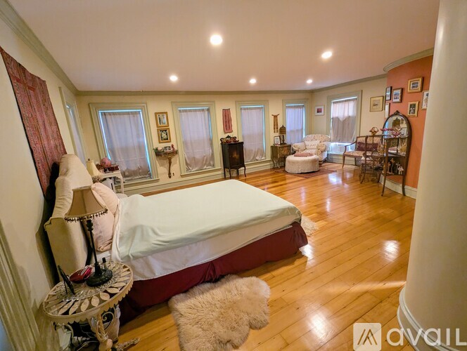 A bedroom with a large bed and a chair.