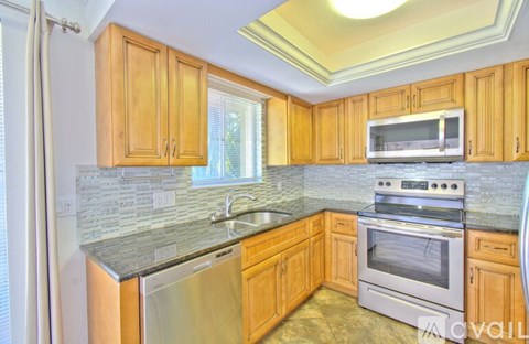 A kitchen with wooden cabinets and stainless steel appliances.