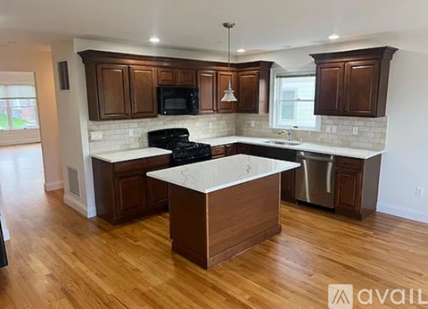 A kitchen with wooden cabinets and a white island.