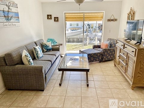 A living room with a grey couch and a wooden cabinet.