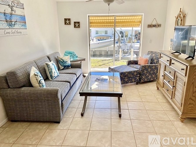 A living room with a grey couch, a coffee table, and a wooden cabinet.