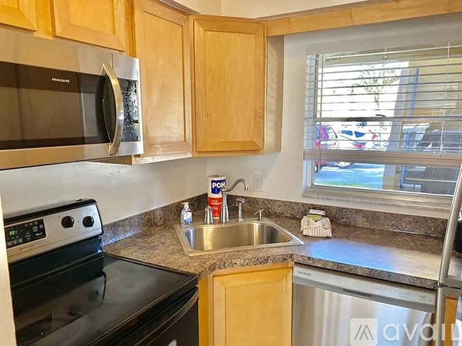 A kitchen with wooden cabinets and a black stove top oven.