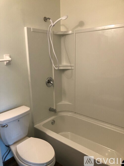 A white toilet is next to a bathtub in a bathroom.
