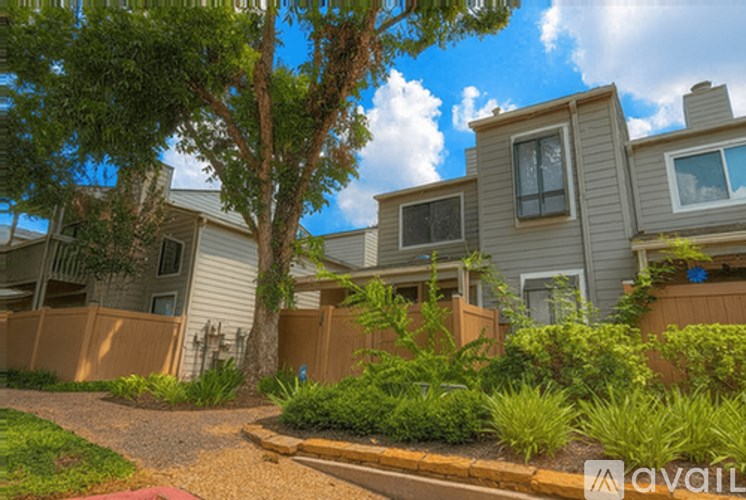 A row of houses with a tree in front of them.