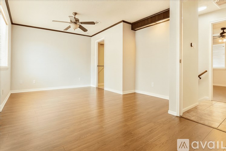 A room with wooden floors and a ceiling fan.