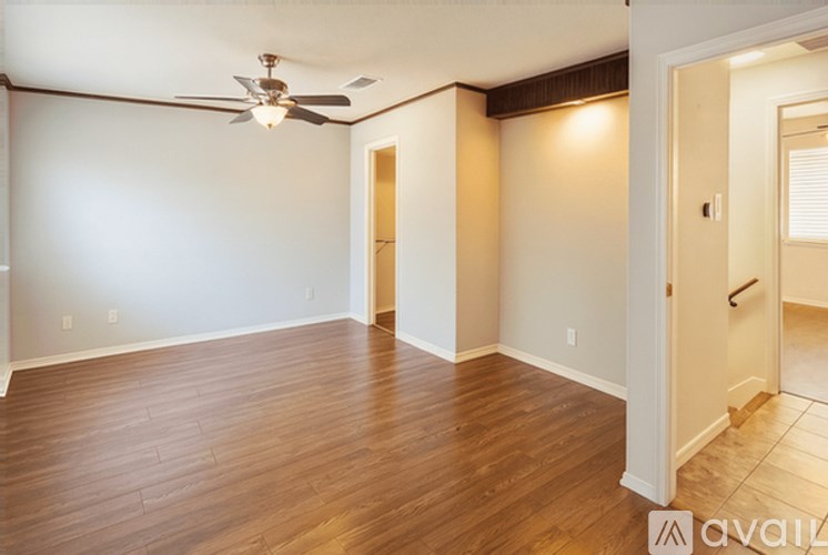 A room with wooden flooring and a ceiling fan.
