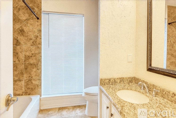A bathroom with a tub, toilet, and sink.