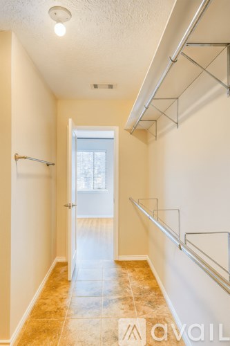 A hallway with a white door and a tiled floor.