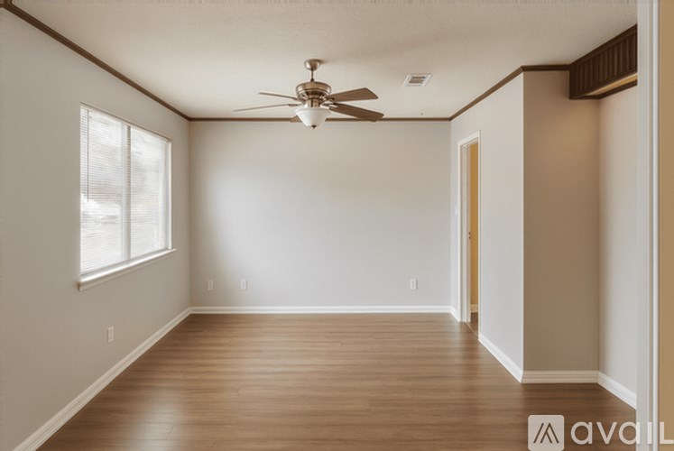A room with a ceiling fan and wooden flooring.