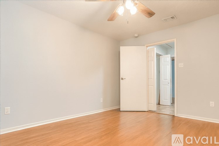 A room with a door and a ceiling fan.