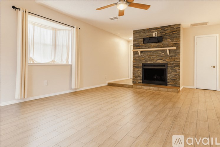 A living room with a fireplace and a flat screen TV mounted above it.