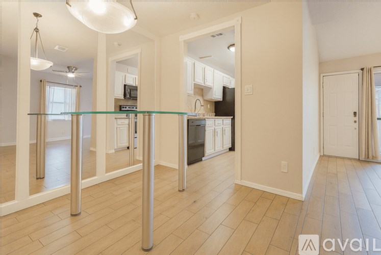 A kitchen with a glass table and white cabinets.