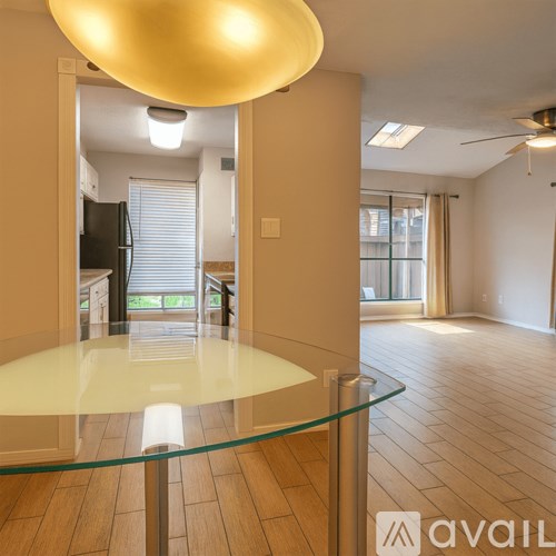 A modern kitchen with a glass table and a ceiling light.