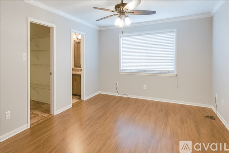 A room with a ceiling fan and a window with blinds.