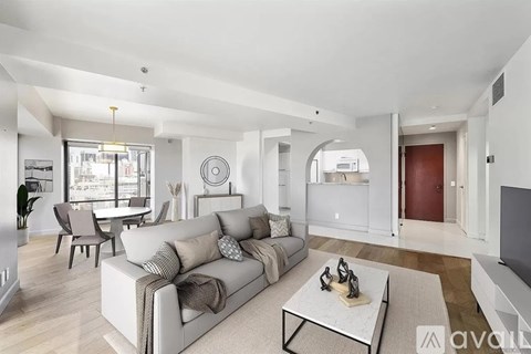 A living room with a grey sofa and a glass coffee table.