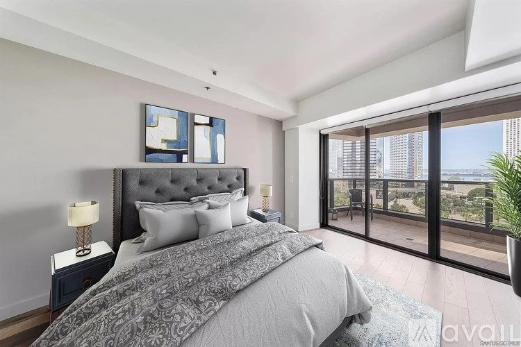 A bedroom with a large bed and a view of the city.