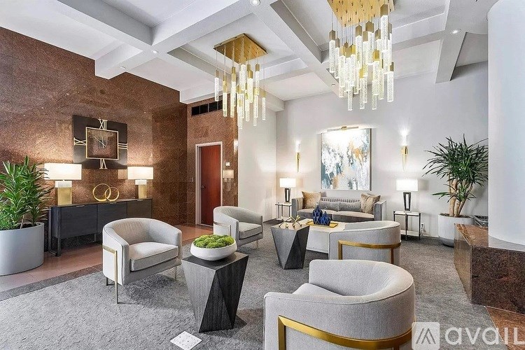 A modern waiting room with a variety of seating options and a chandelier.