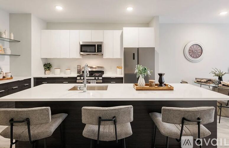A modern kitchen with a large island and bar stools.