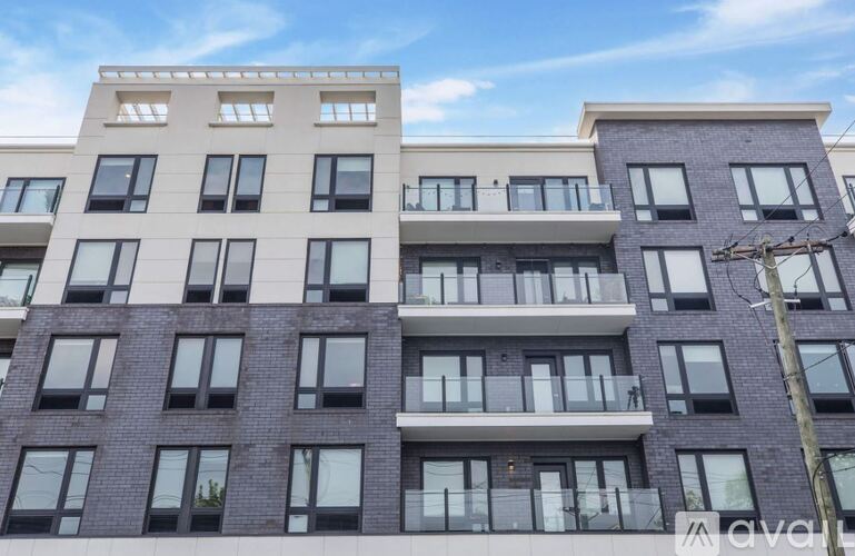 A modern apartment building with balconies and multiple windows.