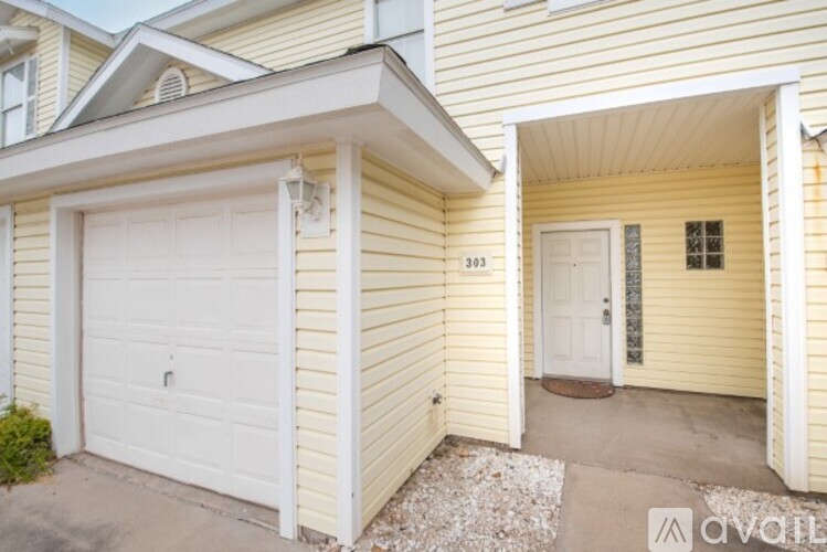 A two-story house with a white garage door and a white door on the second floor.