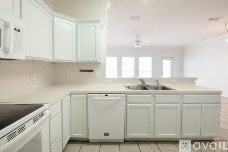 A kitchen with white cabinets and appliances.