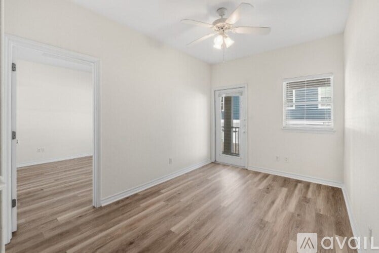 A room with wooden flooring and a ceiling fan.