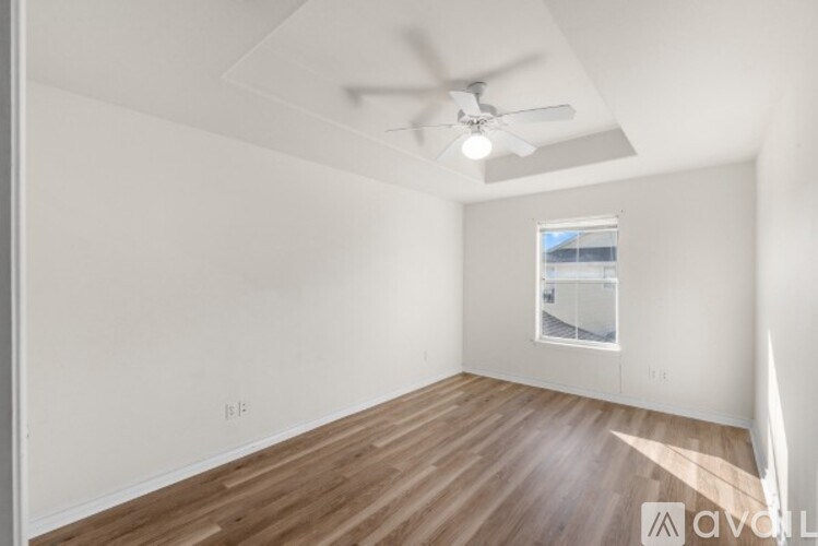 A room with a ceiling fan and a window.