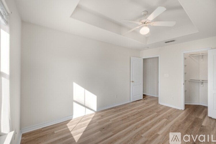 A room with wooden floors and a ceiling fan.