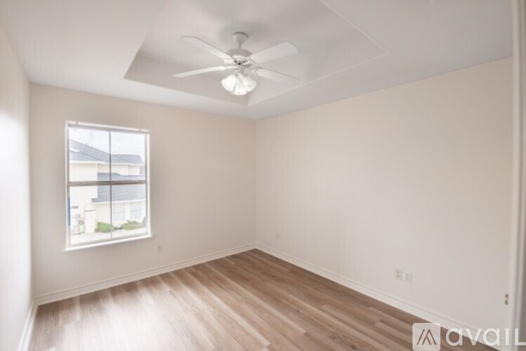 A room with a window and a fan on the ceiling.