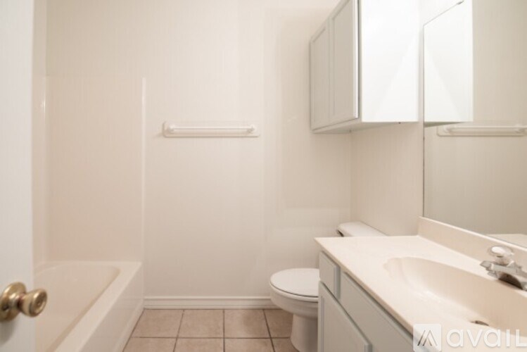 A white bathroom with a toilet, sink, and bathtub.