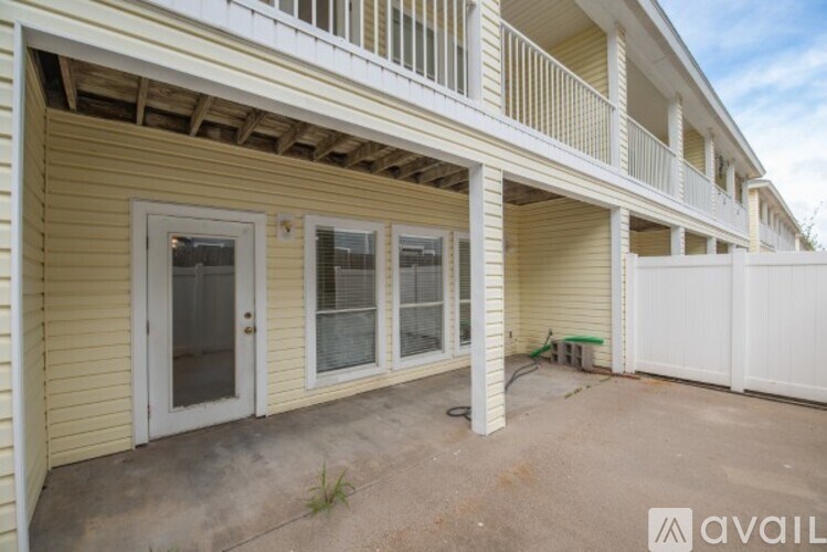 A yellow house with a white fence and a balcony.