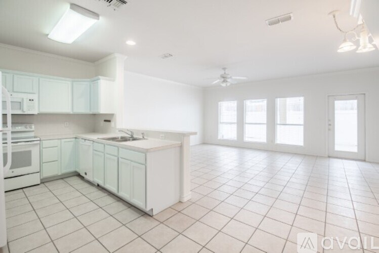 A spacious kitchen with white cabinets and a central island.
