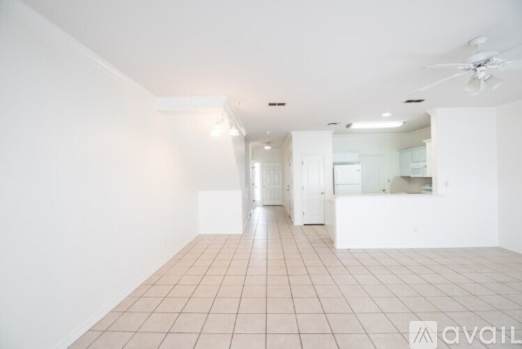 A spacious room with tiled flooring and a ceiling fan.
