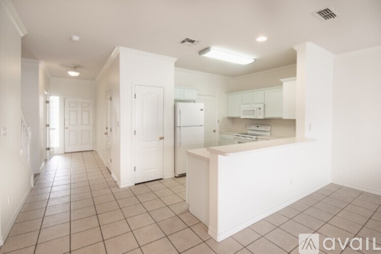 A spacious kitchen with white cabinets and a countertop.