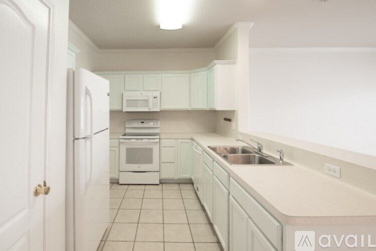 A kitchen with white appliances and cabinets.