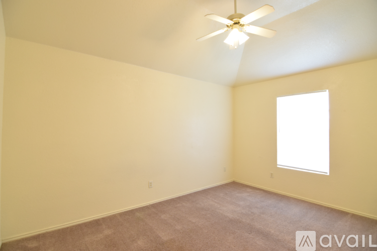 A room with a ceiling fan and a window.