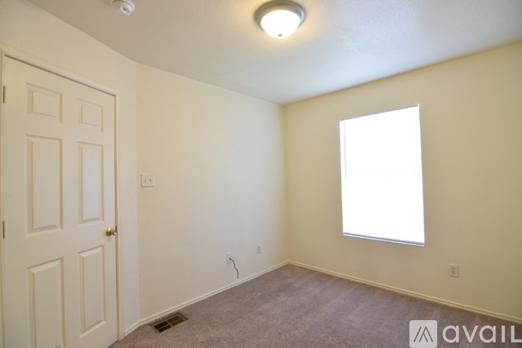 A room with a door, window, and carpeted floor.