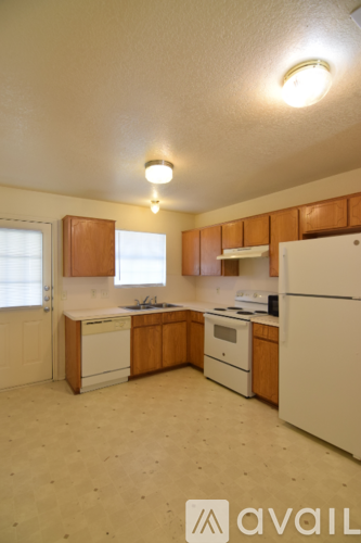 A kitchen with wooden cabinets and white appliances.