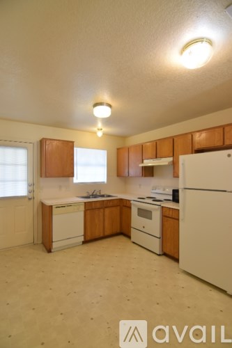 A kitchen with wooden cabinets and white appliances.