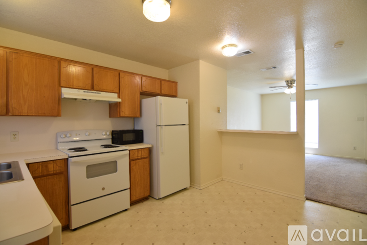 A kitchen with white appliances and wooden cabinets.