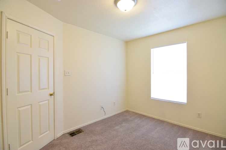 A room with a door, window, and carpeted floor.