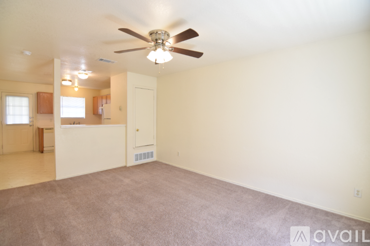 A spacious room with a ceiling fan and carpeted floor.