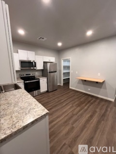 A kitchen with a granite counter top and a refrigerator.