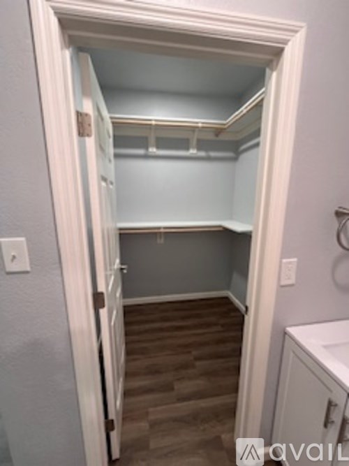 A white door is open to a small room with a shelf and a cabinet.